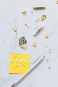 An overhead shot of pencil shavings and a note saying 'Stop Burnout' on white marble